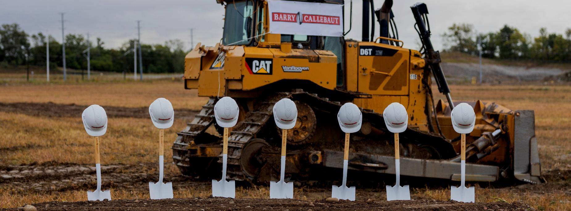 shovels lined up in front of construction vehicle