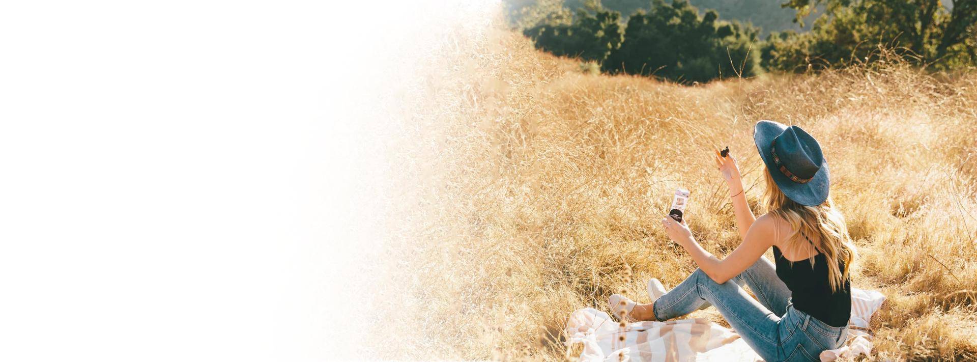 woman sitting on blanket in field 