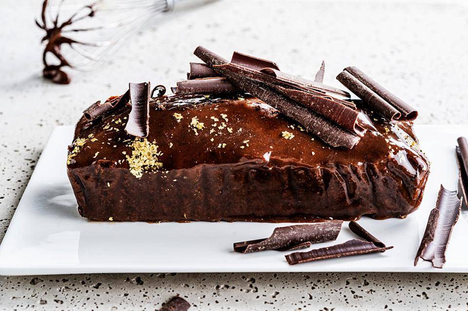 Glazed chocolate cake with gold flakes and chocolate shavings